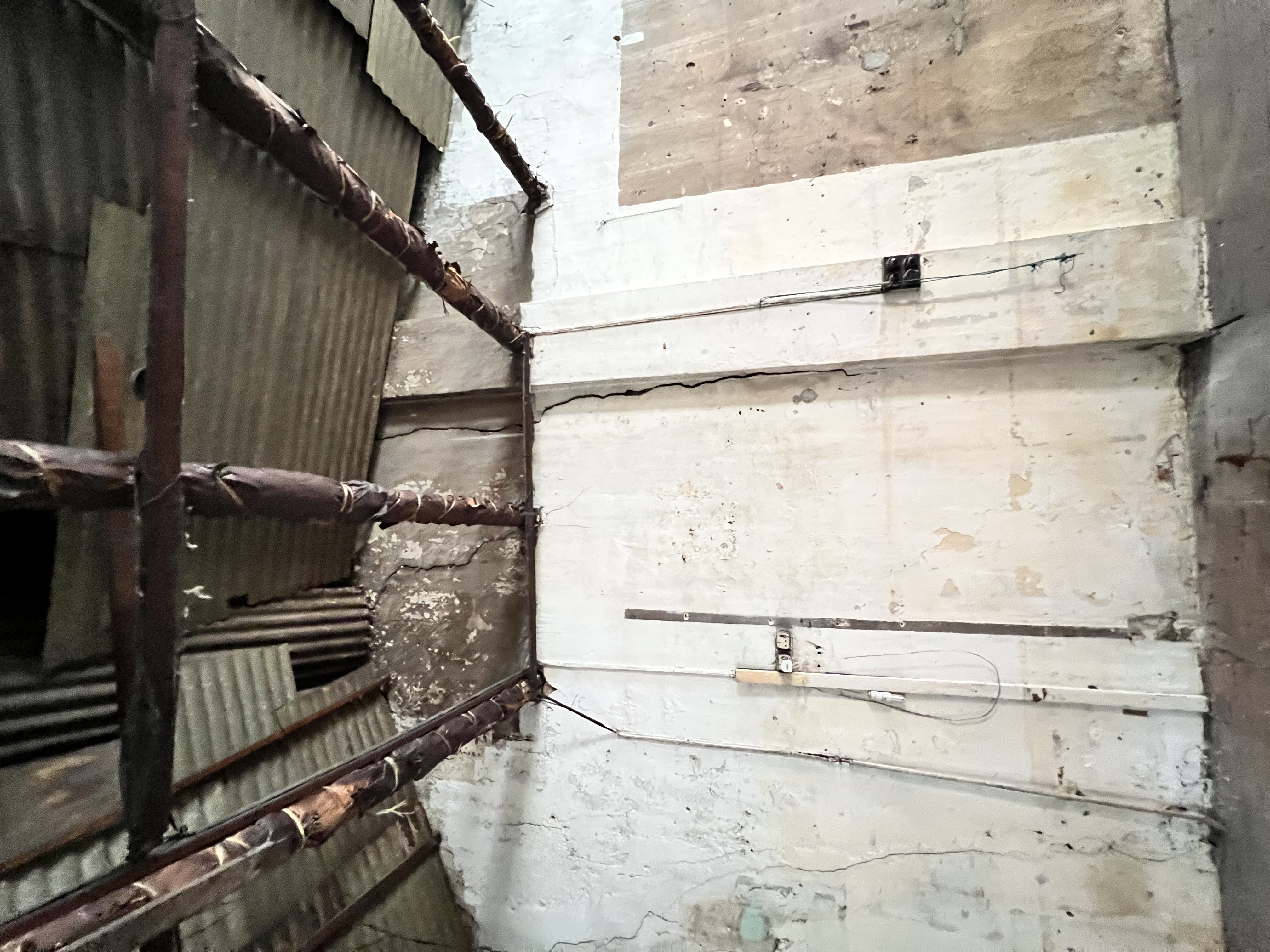 Cracks on the upper wall hinted at roof and structural stress.